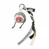 A blind box keychain featuring a character with pink hair and a round head, attached to a braided strap.