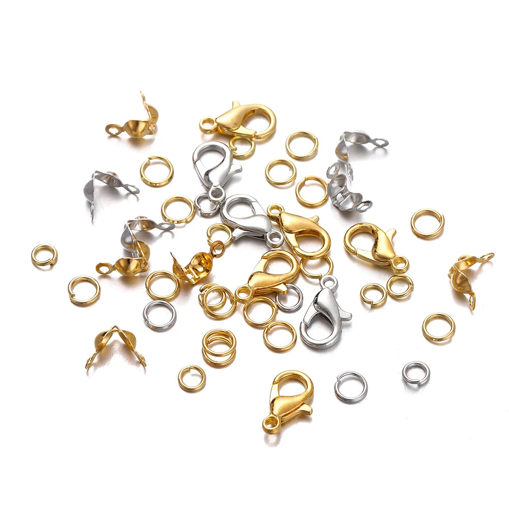 A collection of gold and silver jewelry making components including lobster clasps, jump rings, and crimps.
