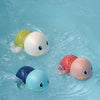 Eine Sammlung bunter, aufblasbarer Uhrwerk-Fischbadspielzeuge, die in klarem blauem Wasser schwimmen.