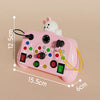 A pink Montessori busy board with various LED light switches and a white rabbit figure for toddlers.