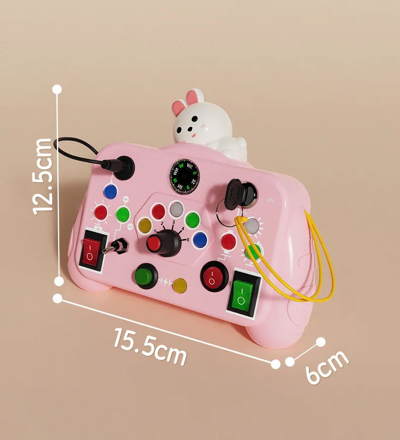 A pink Montessori busy board with various LED light switches and a white rabbit figure for toddlers.