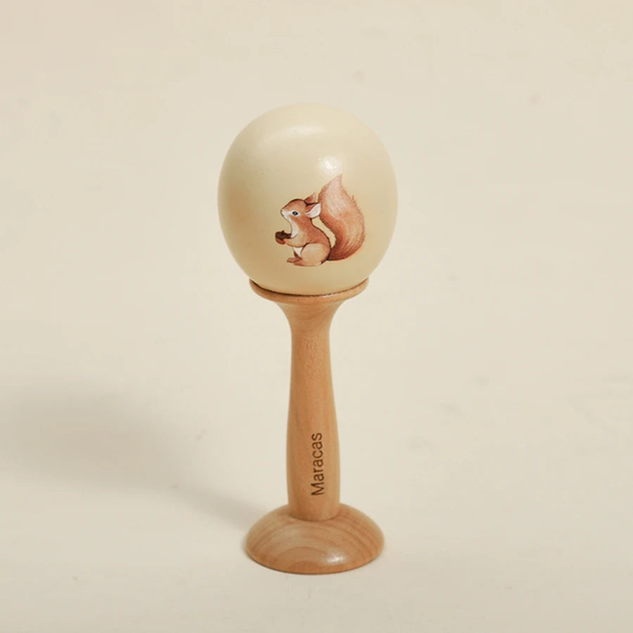 A wooden bear musical instrument set featuring a carved bear on a smooth, light-colored ball mounted on a wooden stand.