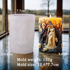 A silicone candle mold shaped like a witch portrait with skulls, displayed on a glass surface.