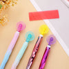 A set of diamond painting pens with various colored plastic rollers and a red plastic tool lying on a light background.