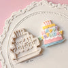 White silicone cake molds featuring a birthday candle design and text on a pink background.