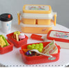 A set of miniature doll picnic lunch boxes in yellow, white, and red colors with handles and food items.