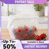 Clear silicone storage bag filled with fresh strawberries and blueberries on a wooden surface.