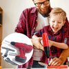 A smiling man is showing a young boy how to use a red electric drill tool set for pretend play.