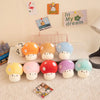 A collection of soft, colorful mushroom plush pillows and decorative signs are displayed on a white surface.