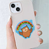A hand holds a white phone case featuring an owl sticker with the text It's okay to ask for help surrounded by a rainbow.