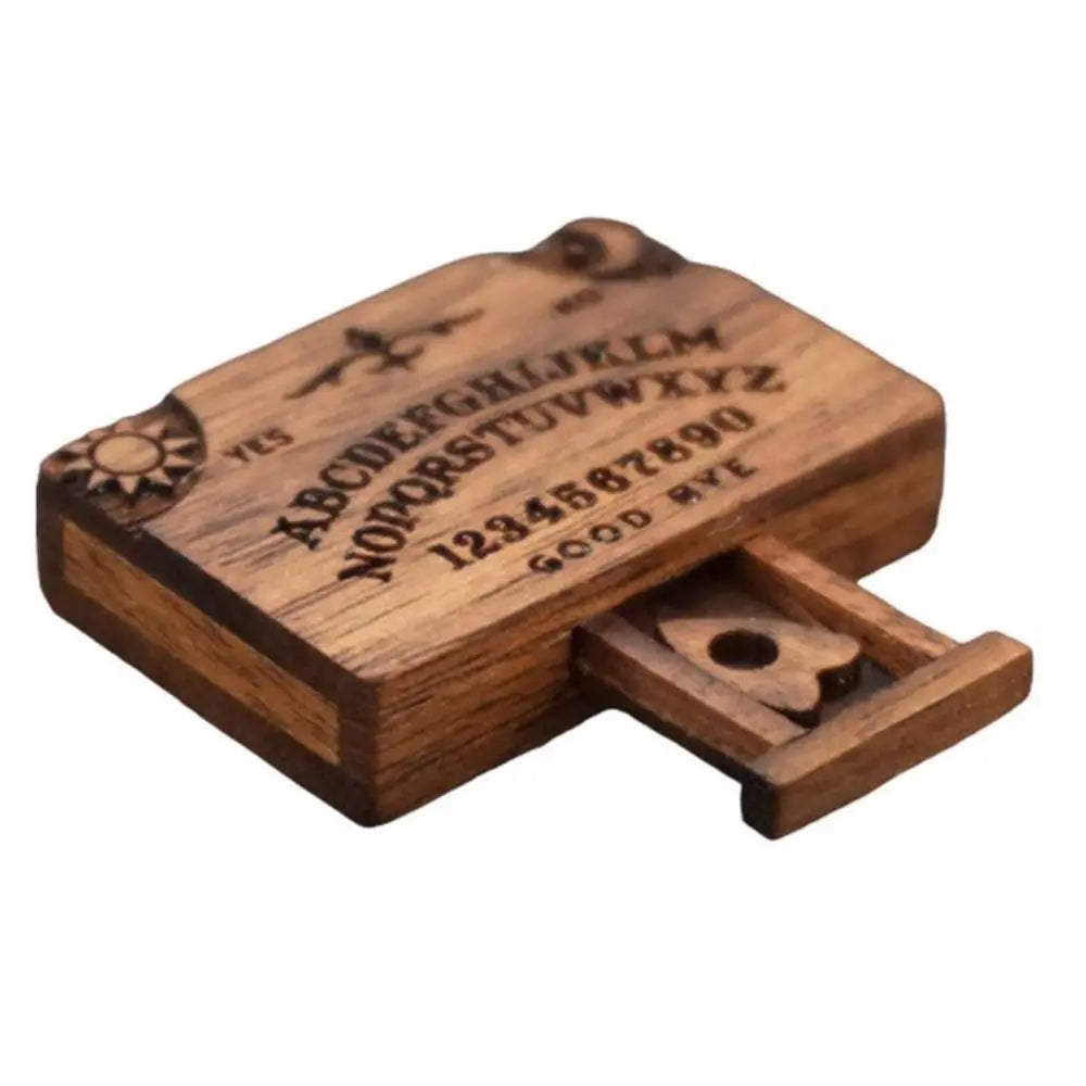A wooden retro miniature Ouija board with a drawer showing the alphabet and numbers.