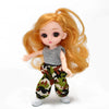 An articulated ball-jointed doll with long orange hair wearing a gray top and camouflage pants.