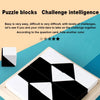 A geometric puzzle block game featuring black and white pieces displayed on a light wooden tray.