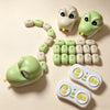 A green plastic snake toy and its remote control are displayed on a light background.