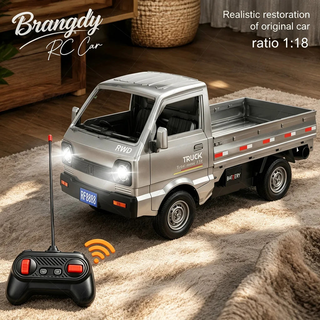 A silver RC truck model is shown on a rug next to its remote control, with a wooden crate in the background.