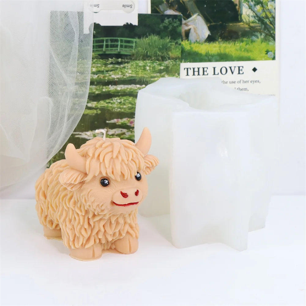 A small, fluffy beige silicone mold shaped like a Highland cow is displayed next to a green label.