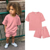A pink kids summer tracksuit set featuring a short sleeve top and matching shorts.