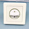A white rotating socket safety cover for baby proofing is shown in a square plastic housing.