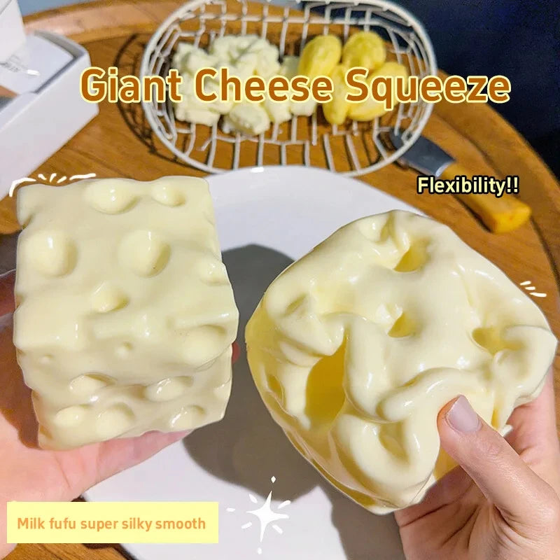 Klebriges Käse-Squeeze-Spielzeug in gelben und weißen Farben, das von einer Hand gepresst wird
