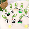 A collection of adorable panda keychains with green clasps displayed on a white plate.