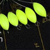 A row of bright yellow oval fishing floats with attached bobber beads are shown against a dark background.