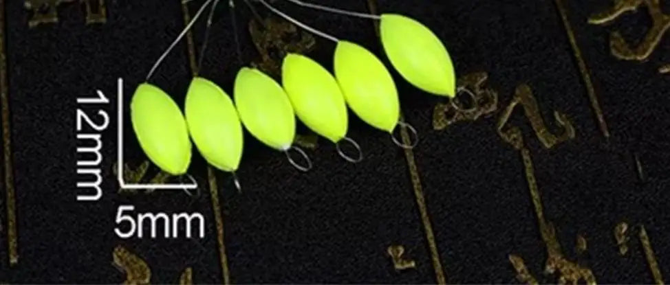 A row of bright yellow oval fishing floats with attached bobber beads are shown against a dark background.