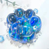 A collection of smooth, iridescent blue and purple acrylic cat paw squishy fidget toys resting on a white surface.