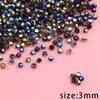 A pile of small, faceted crystal glass beads in various shades of purple, blue, and gold on a pink background.