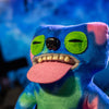 A colorful plush monster doll with large green eyes and a pink tongue is shown in a close-up shot.