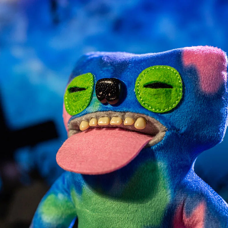 A colorful plush monster doll with large green eyes and a pink tongue is shown in a close-up shot.