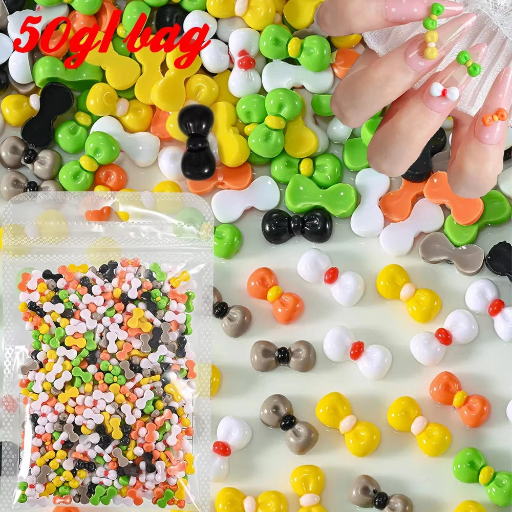 A close-up of various colorful 3D resin nail charms, including yellow, green, orange, and white shapes, scattered on a surfac