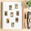A spiral-bound notebook filled with various tarot card illustrations and stickers.