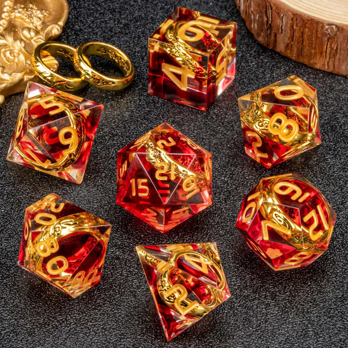 A set of resin dice featuring golden elven numbers on red and clear translucent dice.