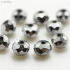 A collection of silver-toned crystal glass beads and round spacers for jewelry making