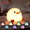 A cute yellow silicone unicorn LED night light resting on a book.