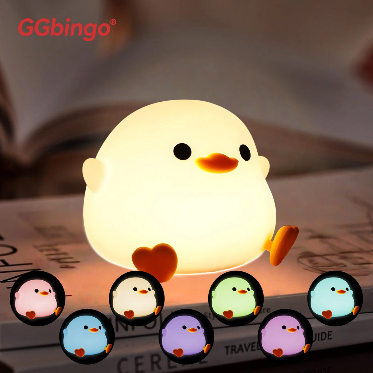 A cute yellow silicone unicorn LED night light resting on a book.