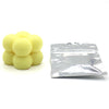 A pile of yellow candle dye chips for soy wax, beeswax, and paraffin.