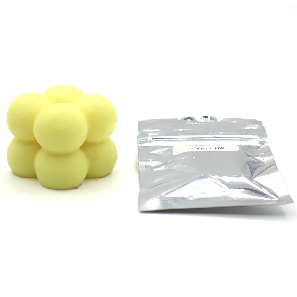 A pile of yellow candle dye chips for soy wax, beeswax, and paraffin.