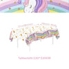 A tablecloth featuring a unicorn design with rainbow stripes and gold stars for a party celebration.