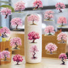 A white ceramic jar filled with pink watercolor peach blossom stickers depicting trees.