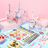 A collection of DIY birthday party goodie bags featuring cups, stickers, and pencils arranged on a light blue surface.