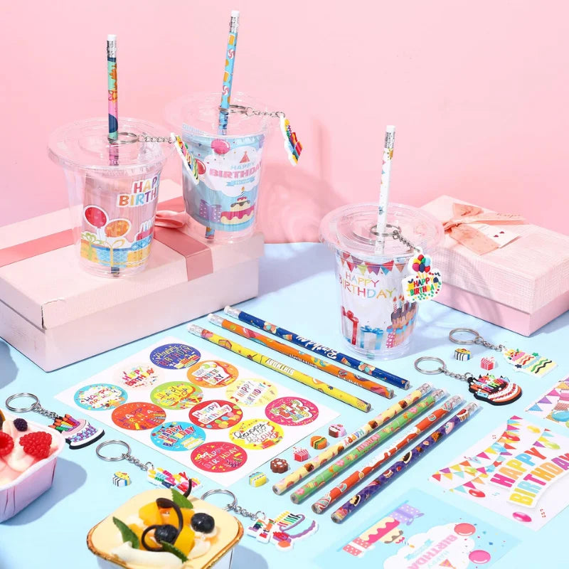 A collection of DIY birthday party goodie bags featuring cups, stickers, and pencils arranged on a light blue surface.