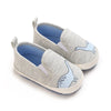 Pair of light gray baby first walker sneakers with a subtle dinosaur print detail.