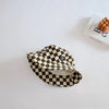 A black and beige checkerboard bucket hat is displayed on a white surface.