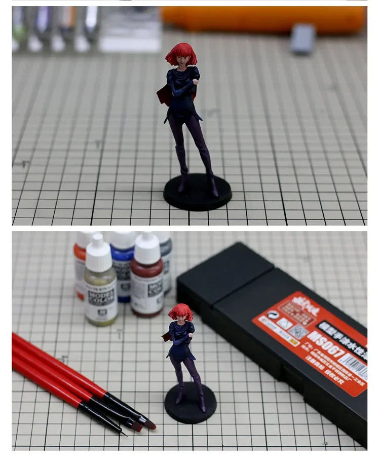 A female figure in a dark blue outfit with red hair is displayed on a black base, next to a set of water-based paint colors.