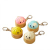 A set of three squishy dumpling keychains in pink, blue, and white with attached metal rings.