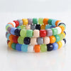 A bracelet of colorful pony beads in various shades of pink, green, yellow, orange, and blue.