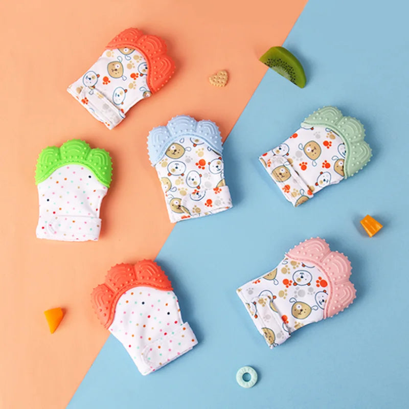 A collection of colorful cartoon baby teething mittens in various pastel shades and patterns arranged on a light orange and b