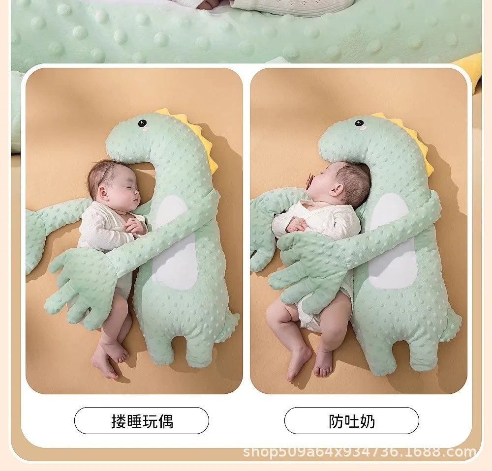 A green plush toy shaped like a dinosaur is being held by a baby, demonstrating a soothing interaction.