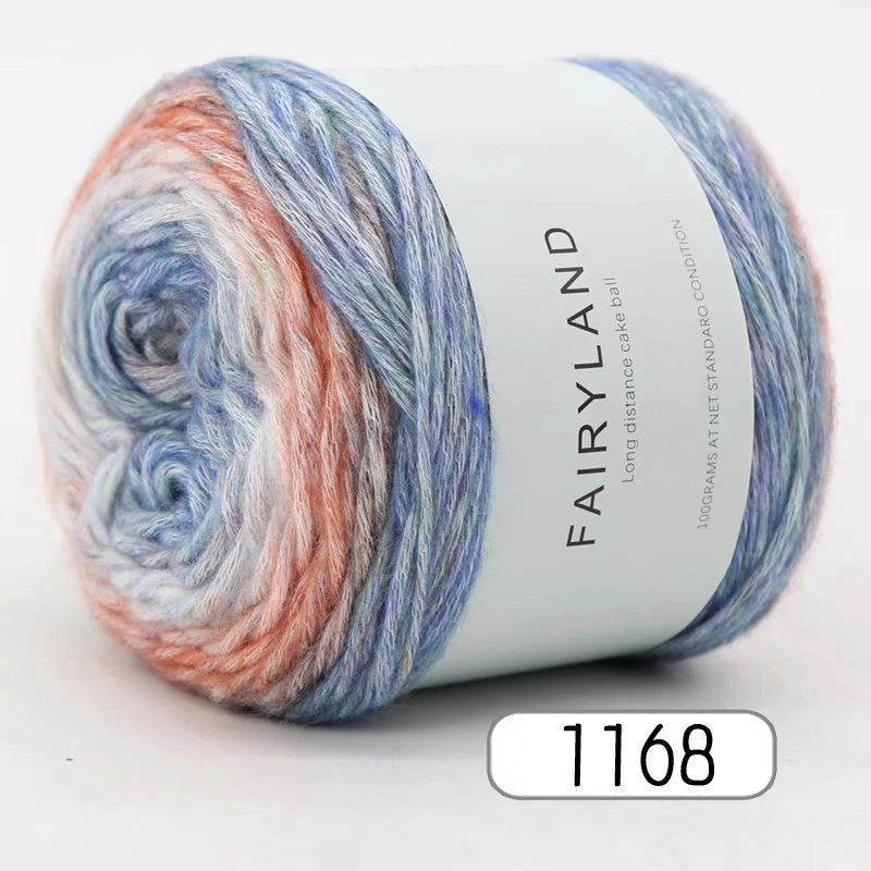 A skein of gradient rainbow yarn labeled Fairyland long distance cake ball